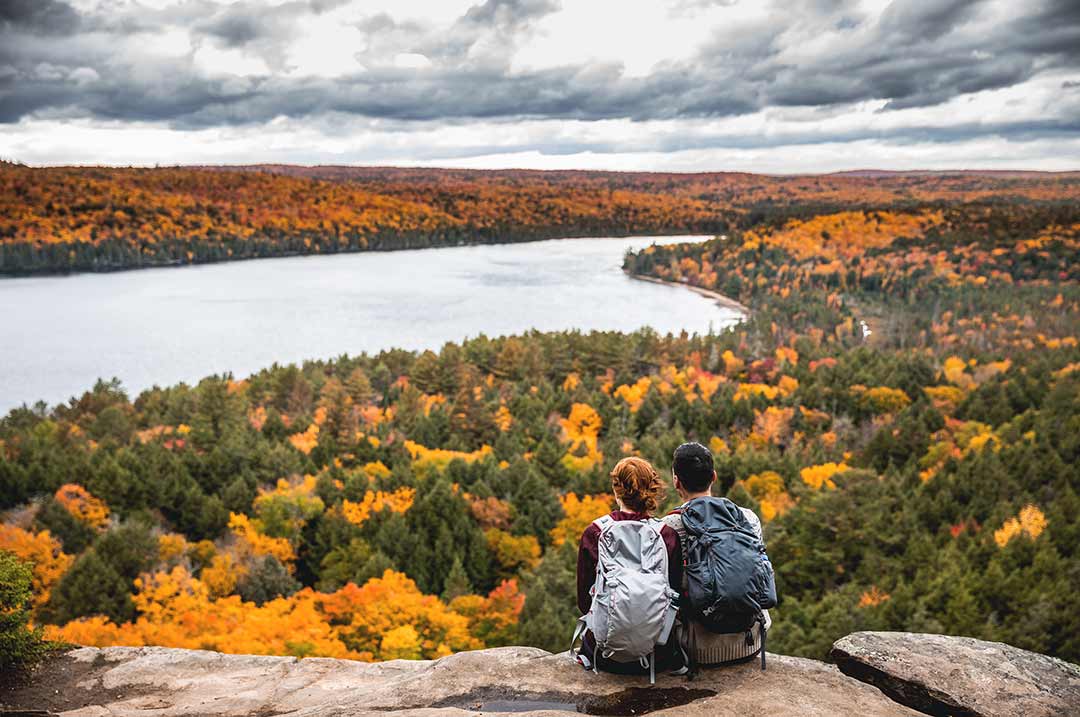 couple sitting at a scenic overlook in the fall