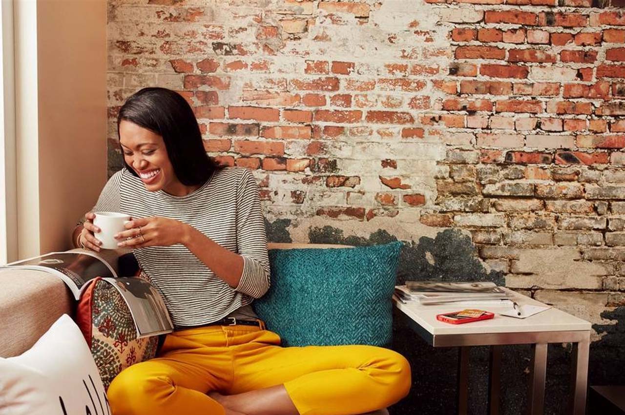 Image of a woman working at a coffee shop, here are some tips on how to work remotely.