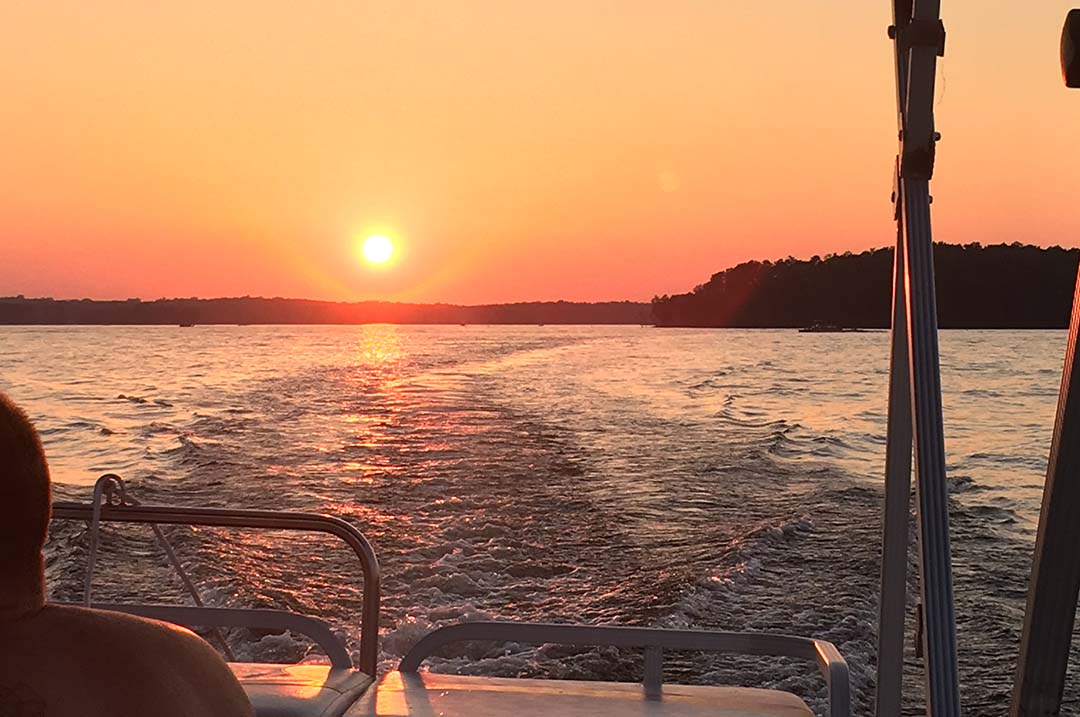 Image of a sunset over Lake Murray, from the back of a boat, one of many great things to do in Columbia, South Carolina.