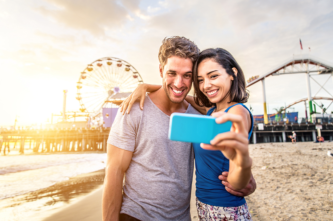 Couple taking a selfie near Santa Monica Pier, one of the best Instagram spots in L.A.