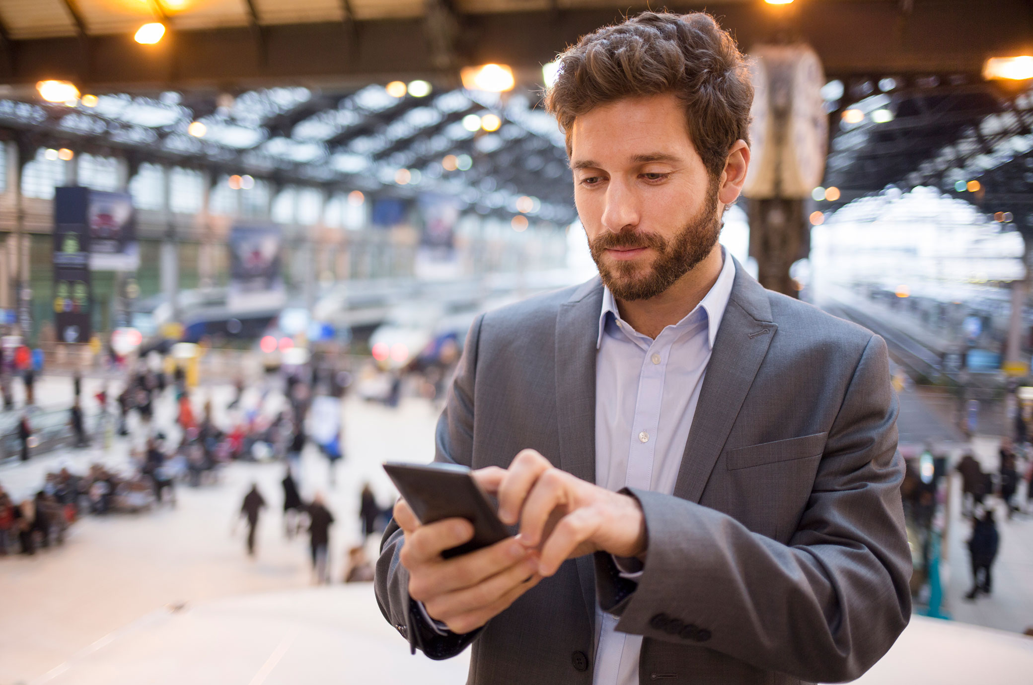 man in an airport using his smartphone
