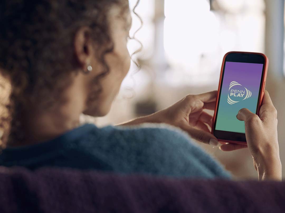 lady using Penn Play app on phone