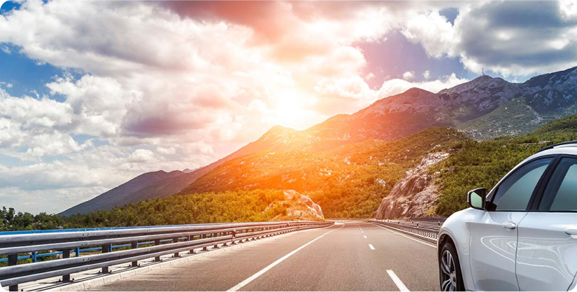Image of sun set in mountain and a car driving on the road