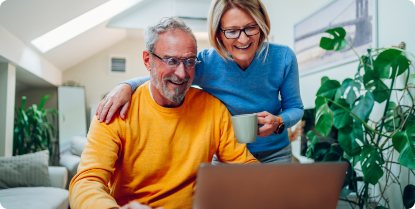 Image of smiling elderly couple looking at laptop screen