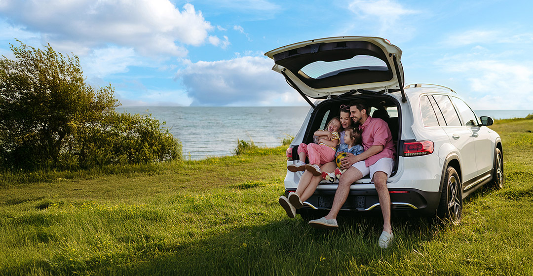 family taking a break on a road trip by the ocean
