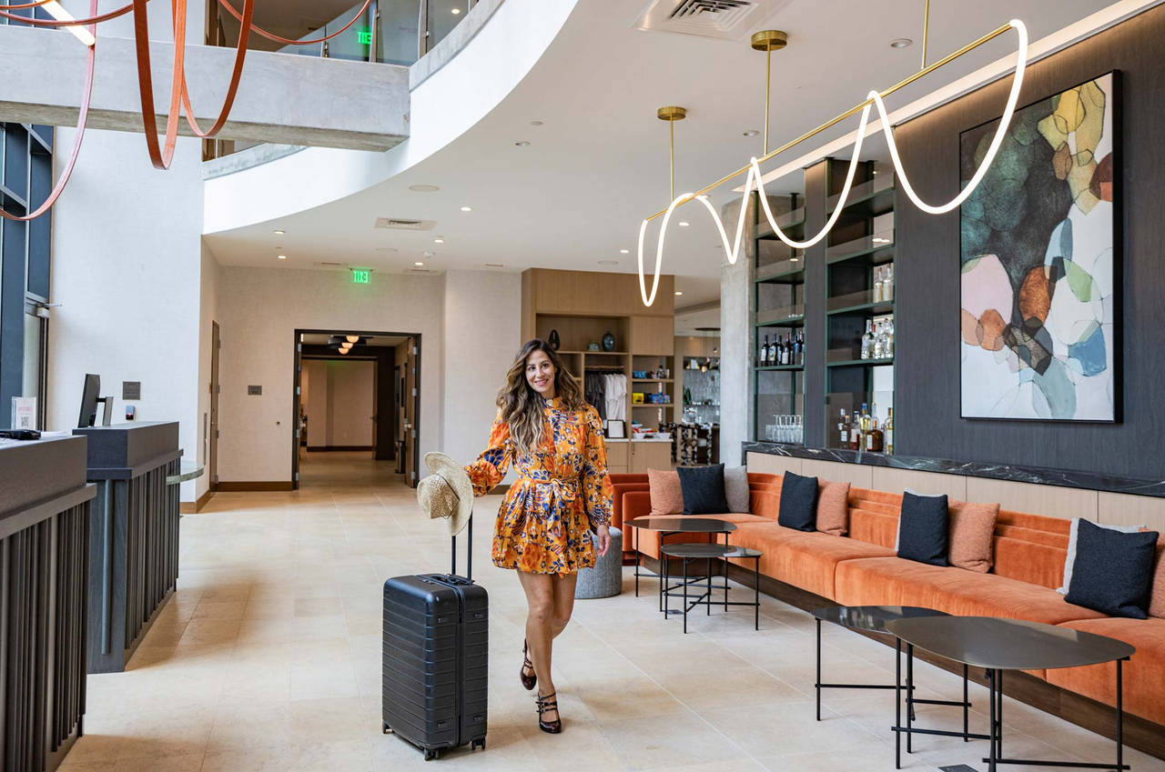 A girl walking with luggage with a smile on face 