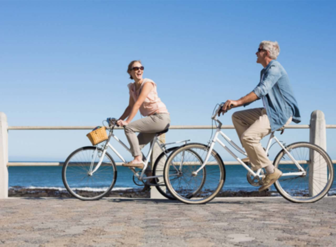 Image of elderly couple happily enjoying bicycle riding