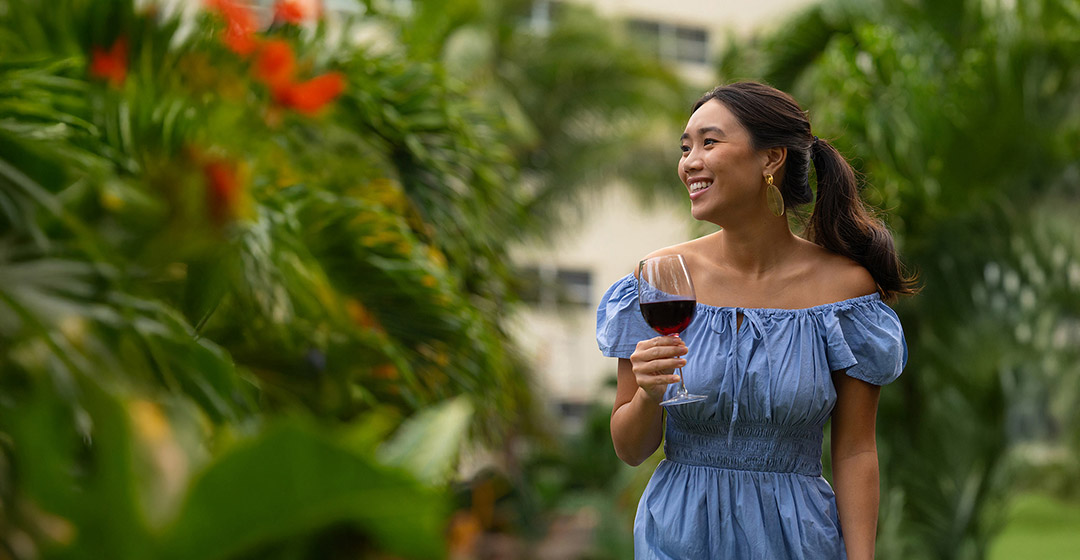 woman enjoying wine outdoors at her hotel
