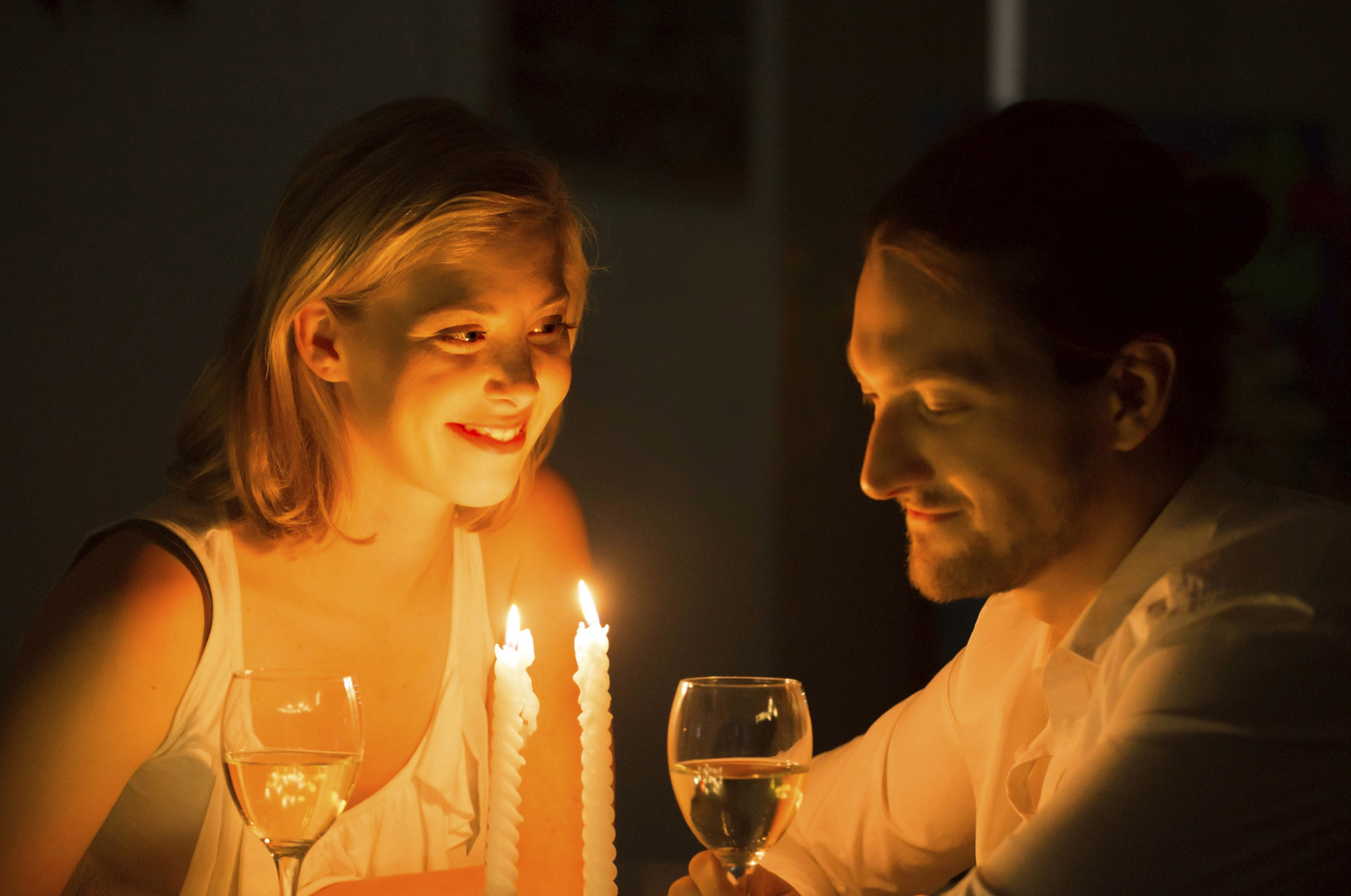 couple drinking wine by candlelight